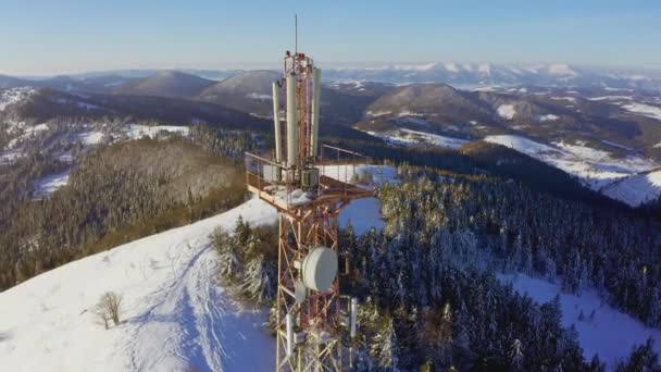 Latanie nad wieżą łączności radiowej, pokryty śniegiem górskim krajobraz zimowy. — Wideo stockowe