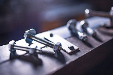 Elle esnek, devasa bir makinede metal krom cıvatalar ve fındıklar. Eski klasik antika makine. Metal işleme için kısmen mekanik inşaat presi.