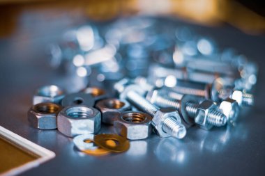 Kapalı metal krom cıvatalar ve kaotik bir sırada fındıklar. Bağlayıcılar ve inşaat konuları için arka plan konsepti. Yedek parça konseptini onar