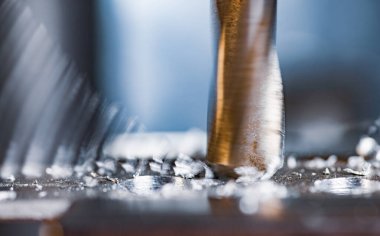 Bir alet çilingirinin iş yerinde talaşı yakın çekim, sondaj makinesi ile sondaj işlemi