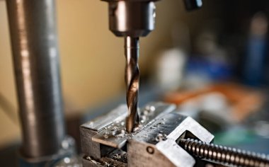 Bir alet çilingirinin iş yerinde talaşı yakın çekim, sondaj makinesi ile sondaj işlemi