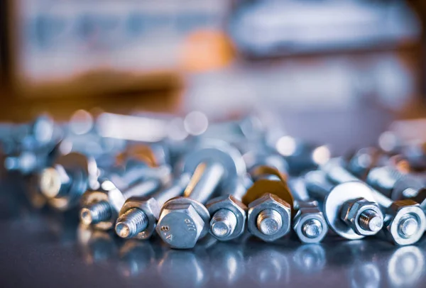 Boulons et écrous en métal chromé dans un ordre chaotique fond industriel — Photo