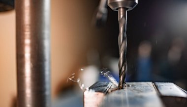 Bir alet çilingirinin iş yerinde talaşı yakın çekim, sondaj makinesi ile sondaj işlemi