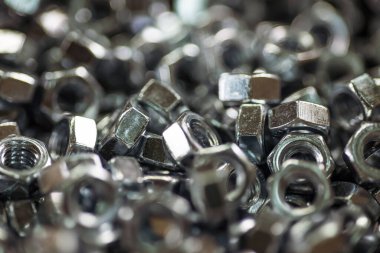 Kaotik bir sırayla yakın plan metal krom fındıklar. Bağlayıcılar ve inşaat konuları için arka plan konsepti. Yedek parça konseptini onar