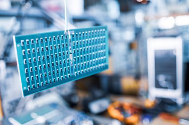 Otomatik ısıtma sistemi üretiminde bir SMD direnç panelinin yakın görüntüsü yer almaktadır. Sanayi ve stratejik amaçlar için endüstriyel ekipman üretimi kavramı