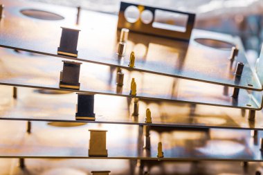 Metal tahtalar ve aksesuarlar modern uzmanlaşmış bilgisayar ve tıbbi ekipman üretimi sırasında yüzeyde yatar. Teknoloji üretimi kavramı