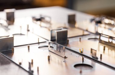 Metal tahtalar ve aksesuarlar modern uzmanlaşmış bilgisayar ve tıbbi ekipman üretimi sırasında yüzeyde yatar. Teknoloji üretimi kavramı