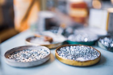 Küçük metal cıvatalar ve bir ingiliz anahtarı derleyicinin çalışma masasında kaotik bir düzende yatıyor. Bağlayıcılar ve inşaat konuları için arka plan konsepti. Yedek parça konseptini onar