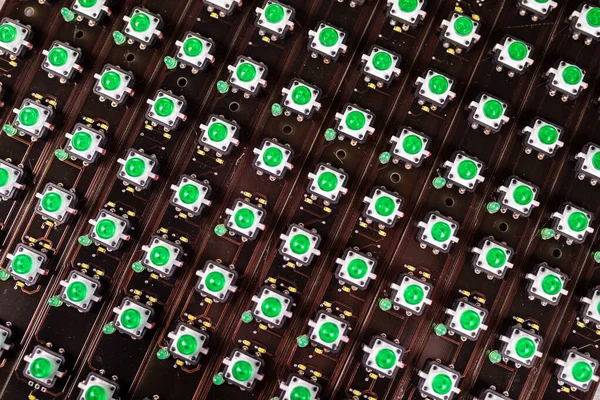 Close-up of a LED panel of green light indicators is in the production. The concept of industrial production of equipment for military and strategic purposes