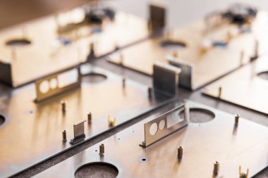 Metal tahtalar ve aksesuarlar modern uzmanlaşmış bilgisayar ve tıbbi ekipman üretimi sırasında yüzeyde yatar. Teknoloji üretimi kavramı