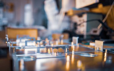 Metal tahtalar ve aksesuarlar modern uzmanlaşmış bilgisayar ve tıbbi ekipman üretimi sırasında yüzeyde yatar. Teknoloji üretimi kavramı