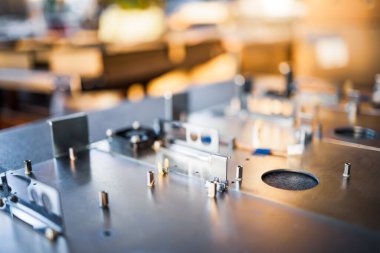 Metal tahtalar ve aksesuarlar modern uzmanlaşmış bilgisayar ve tıbbi ekipman üretimi sırasında yüzeyde yatar. Teknoloji üretimi kavramı