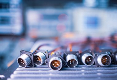 Fişler için yakın çekim bulanık metal prizler beyaz bir masanın üzerindeki yığının içinde. Bilgisayar televizyonu ve ses hoparlörlerinin üretimi için kavram