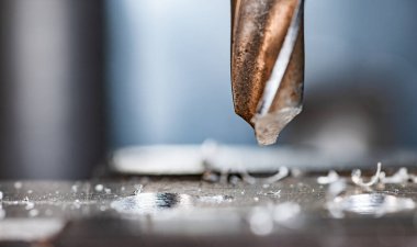 Bir alet çilingirinin iş yerinde talaşı yakın çekim, sondaj makinesi ile sondaj işlemi