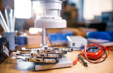 Büyük modern elektron mikroskobu ve gömülü mikro devreler bilimsel bir laboratuarda elektronik bileşenlerin araştırılmasına hazırlanmak için test plakasına istiflenmiştir.