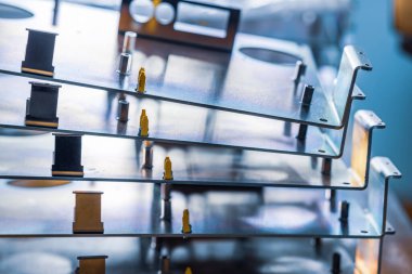 Metal tahtalar ve aksesuarlar modern uzmanlaşmış bilgisayar ve tıbbi ekipman üretimi sırasında yüzeyde yatar. Teknoloji üretimi kavramı