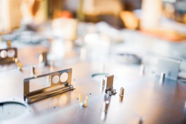 Metal tahtalar ve aksesuarlar modern uzmanlaşmış bilgisayar ve tıbbi ekipman üretimi sırasında yüzeyde yatar. Teknoloji üretimi kavramı