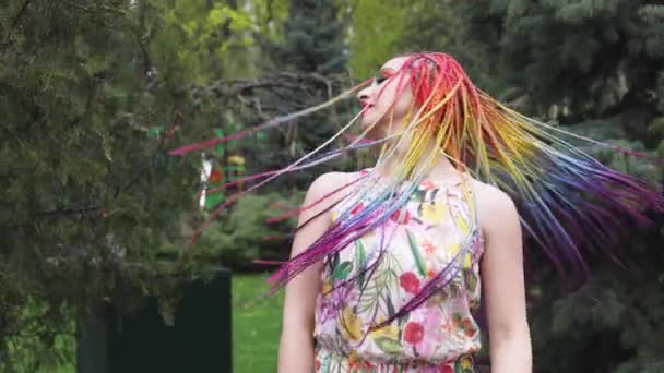 Tyttö onnellinen hymy mekko Afrikkalainen punokset ja meikki pyörteitä ja heittää hiuksensa ylös keväällä sateinen puisto — kuvapankkivideo
