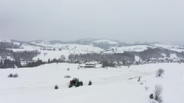 Tractorul îndepărtează zăpada de pe drumul acoperit cu zăpadă, astfel încât mașinile să poată trece — Videoclip de stoc