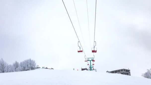 Impianti di risalita, sciatori e snowboarder, località nelle montagne carpatiche, time lapse — Video Stock