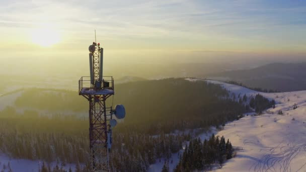 Voando sobre a torre de comunicações de rádio, neve de montanha coberto paisagem de inverno. — Vídeo de Stock