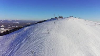 Karlı bir dağ yamacında eski bir kayak istasyonu Kayak ve snowboard yapan bir sürü insan var