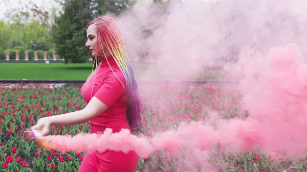 Een meisje met make-up met regenboog vlechten in rode jurk poseren in rode jurk — Stockfoto