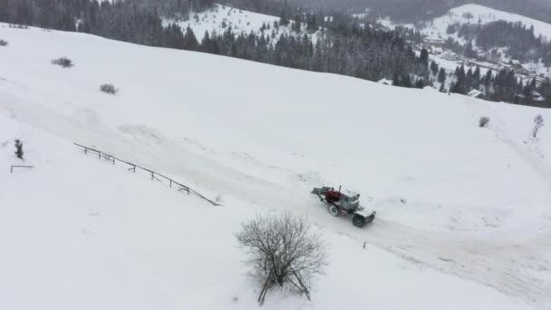 拖拉机把雪从被雪覆盖的路上移走，这样汽车就能通过了 — 图库视频影像
