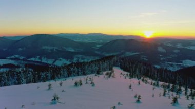 Sıradışı bir vadi tepeler ve dağlarla kaplı köknar ormanlarıyla parlak, alevli bir günbatımının arka planına karşı
