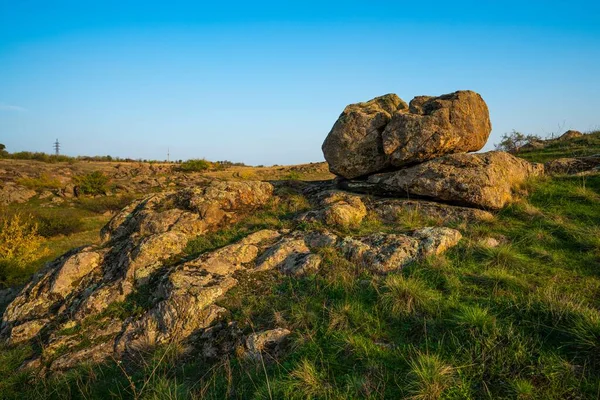 Uma pequena pilha de pedras em um campo verde-amarelo contra o fundo de um céu na Ucrânia — Fotografia de Stock