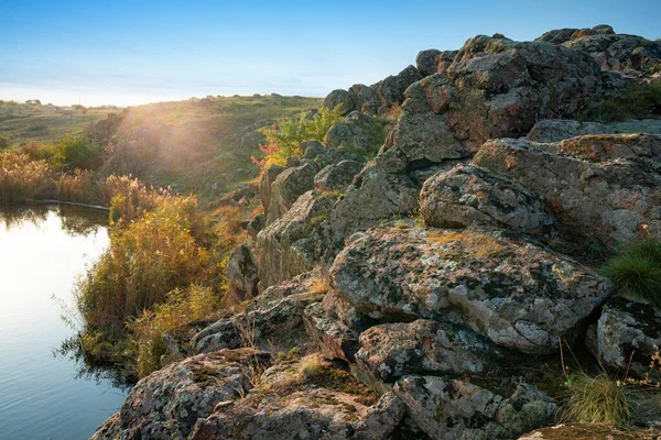 美しいウクライナの空の背景に緑黄色のフィールドに石の小さな山 — ストック写真