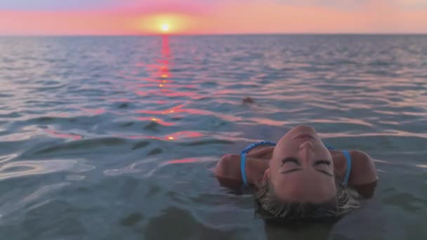 Una chica con hermosos rasgos faciales mira a una distancia desconocida mientras está sentada en el estuario — Vídeos de Stock