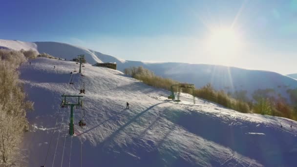 Estação de esqui velha em uma encosta de montanha nevada com um monte de pessoas em esquis e snowboards — Vídeo de Stock