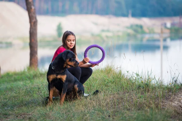 Mädchen und Hund am Rande einer Klippe spielen mit einem Klingelschild und genießen den Morgen im Wald — Stockfoto