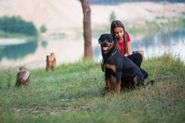 Chica y perro en el borde de un acantilado jugando con un anillo y disfrutando de la mañana en el bosque —  Fotos de Stock