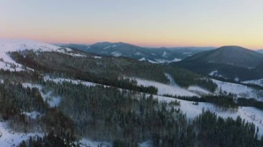 Sıradışı bir vadi tepeler ve dağlarla kaplı köknar ormanlarıyla parlak, alevli bir günbatımının arka planına karşı