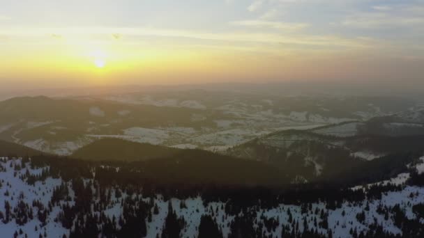 Egy rendkívüli völgy dombokkal és hegyekkel borítva fenyőerdőkkel a fényes, tüzes naplemente hátterében. — Stock videók