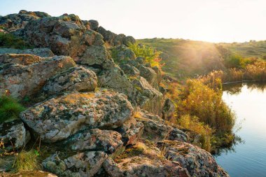 Güzel Ukrayna 'da, yeşil-sarı bir tarlada, gökyüzünün arka planında küçük bir taş yığını.