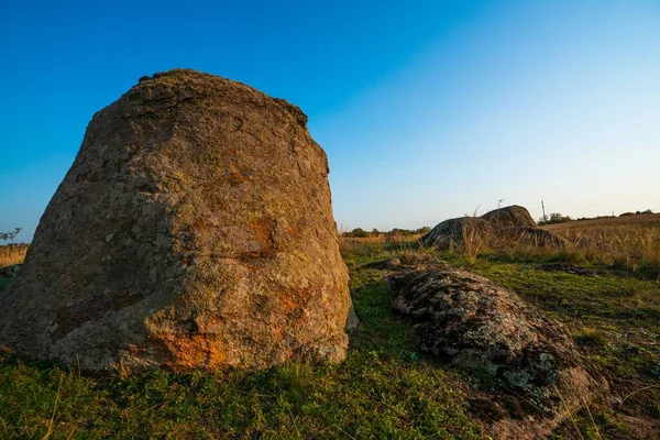 Ein kleiner Steinhaufen in einem grün-gelben Feld vor dem Hintergrund eines Himmels in der Ukraine — Stockfoto