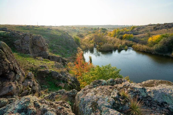 美しいウクライナの空の背景に緑黄色のフィールドに石の小さな山 — ストック写真