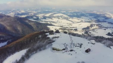 Karlı bir dağ yamacında eski bir kayak istasyonu Kayak ve snowboard yapan bir sürü insan var