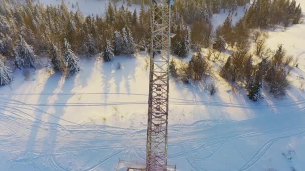 Πετώντας πάνω από πύργο ραδιοεπικοινωνιών, χιόνι βουνό καλύπτονται χειμερινό τοπίο. — Αρχείο Βίντεο