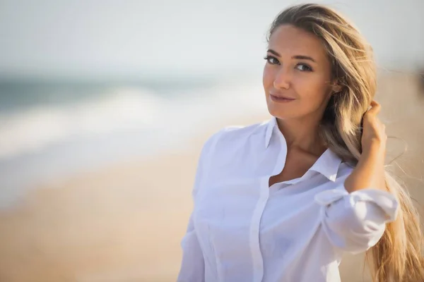 Retrato de uma menina em um maiô azul e camisa branca contra o fundo do mar azul e céu claro — Fotografia de Stock