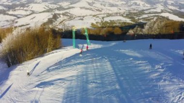 Karlı bir dağ yamacında eski bir kayak istasyonu Kayak ve snowboard yapan bir sürü insan var