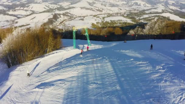 Stasiun ski tua di lereng gunung bersalju dengan banyak orang di ski dan papan salju — Stok Video