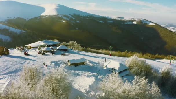 Oud skigebied op een besneeuwde berghelling met veel mensen op ski 's en snowboards — Stockvideo