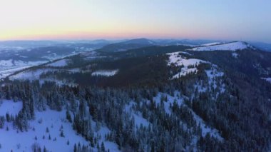 Sıradışı bir vadi tepeler ve dağlarla kaplı köknar ormanlarıyla parlak pembe bir günbatımının arka planına karşı