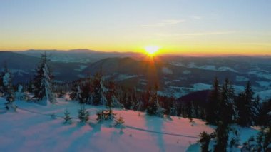 Sıradışı bir vadi tepeler ve dağlarla kaplı köknar ormanlarıyla parlak, alevli bir günbatımının arka planına karşı