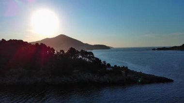 Mavi bulutlu gökyüzünde parlayan yaz güneşi Karadağ dağlarının siluetlerini ve ünlü Kotor Körfezi kıyılarını aydınlatıyor. UHD Video gerçek zamanlı 4K