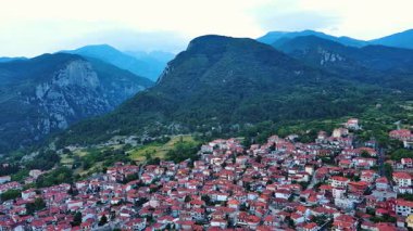 Küçük Yunan sakin kasabası Litochoro 'da kırmızı kiremit çatılı küçük evler ve dar sokaklar ile ünlü yüksek Olimpos Dağı ve bulutlu bir gökyüzü. UHD Video gerçek zamanlı 4K